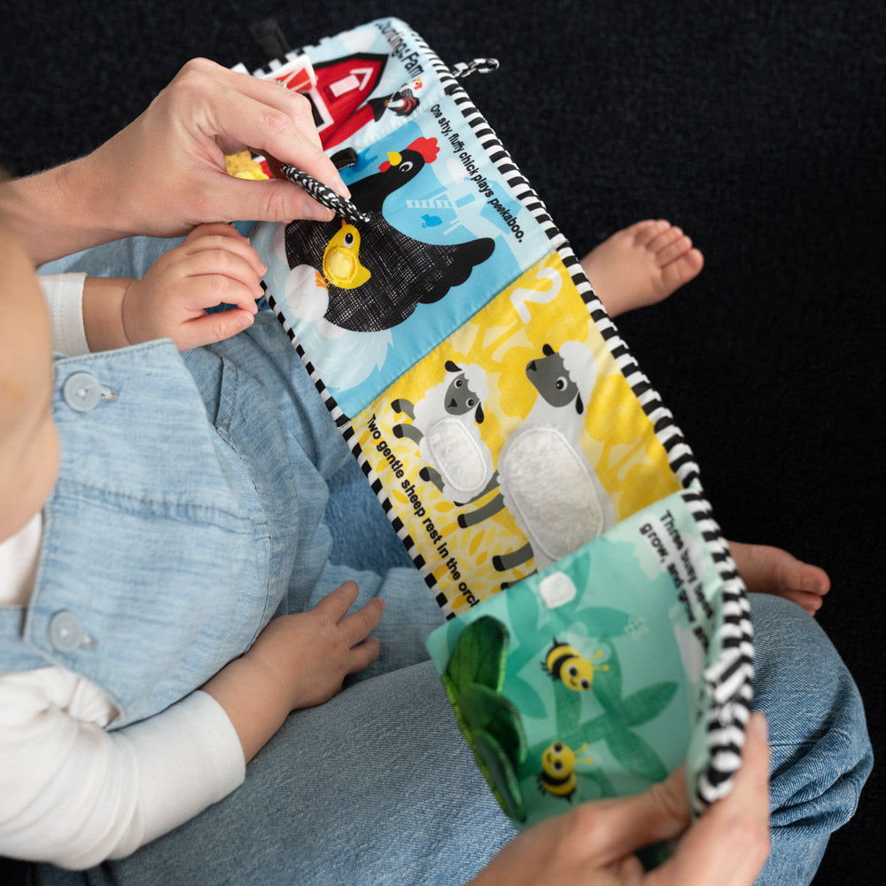 Baby playing with the Baby Einstein Counting At The Farm Soft Activity Book