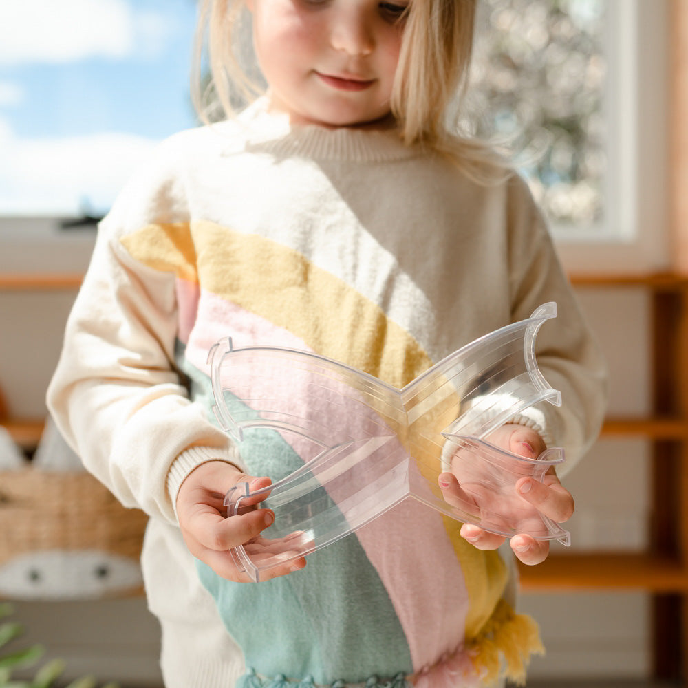 Child holding the CONNETIX Magnetic Tiles 66 Piece - Rainbow Ball Run Expansion Pack