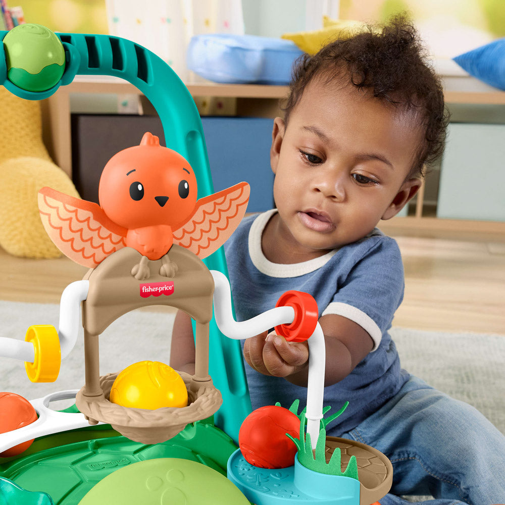 Baby playing with the interactive elements of the Fisher-Price Turtle Walker.