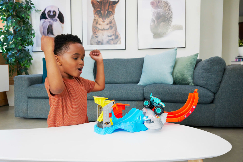 Child playing with the Hot Wheels Monster Trucks Sharks vs Dinos Spiral Track Set