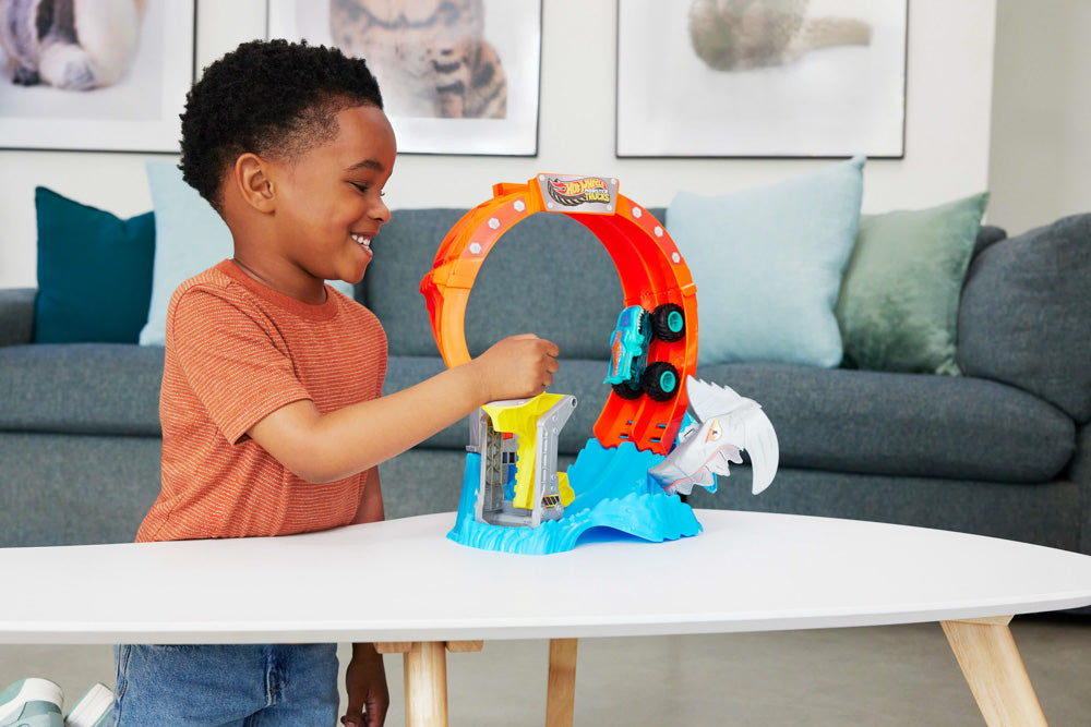 Child playing with the Hot Wheels Monster Trucks Sharks vs Dinos Spiral Track Set