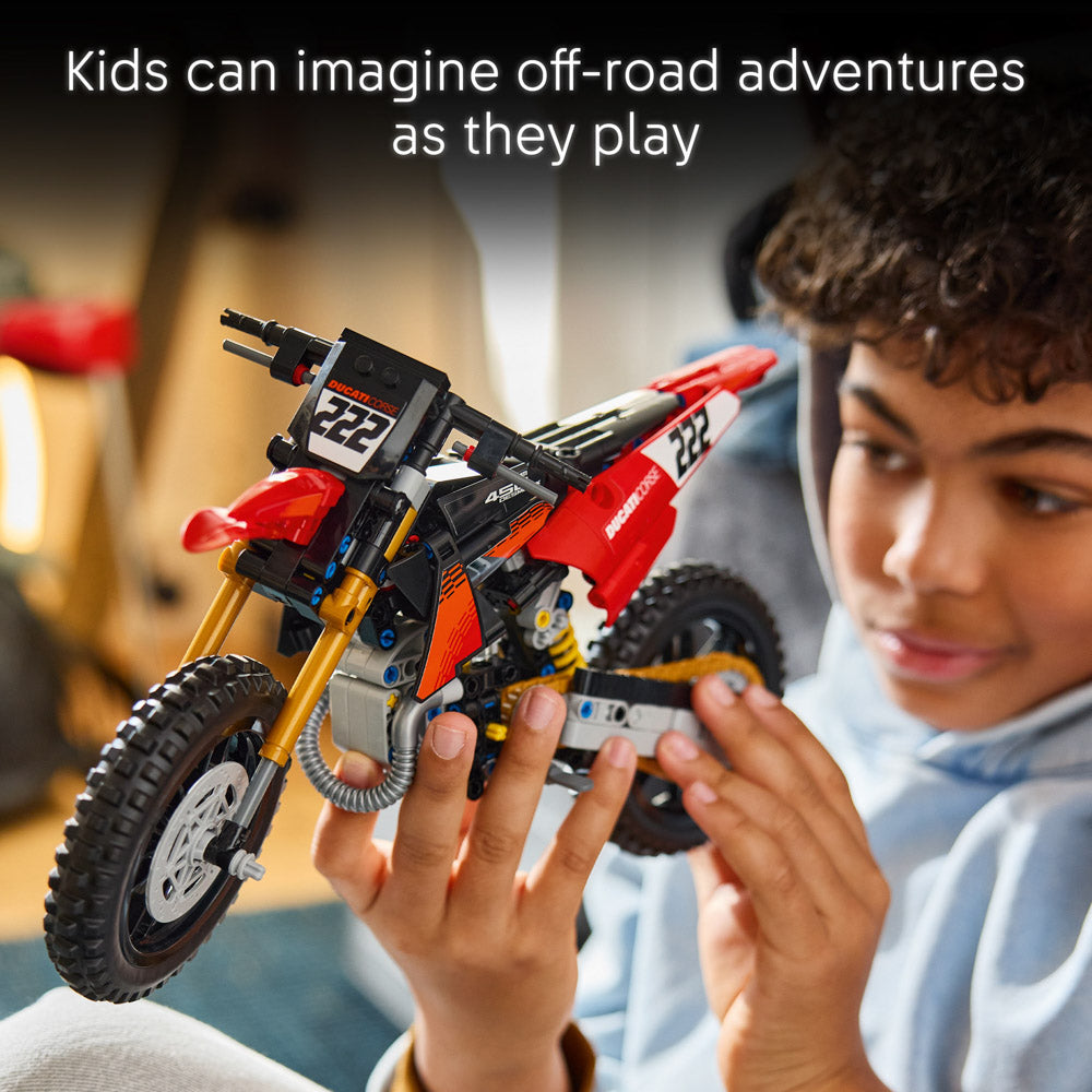 Boy holding an assembled LEGO 42238 Technic Ducati Desmo450 MX Factory Motorcycle set