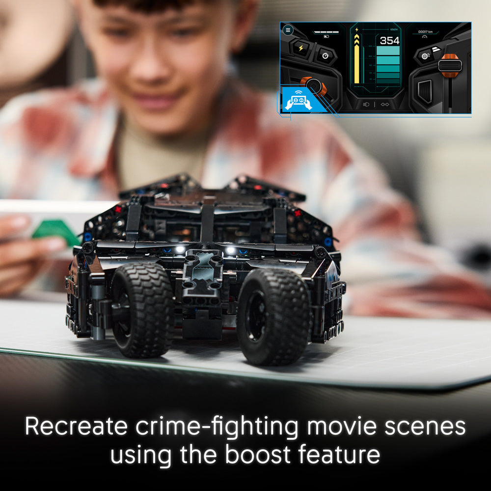 Boy building the LEGO 42239 Technic Batman Batmobile Tumbler Car set with remote-control function.