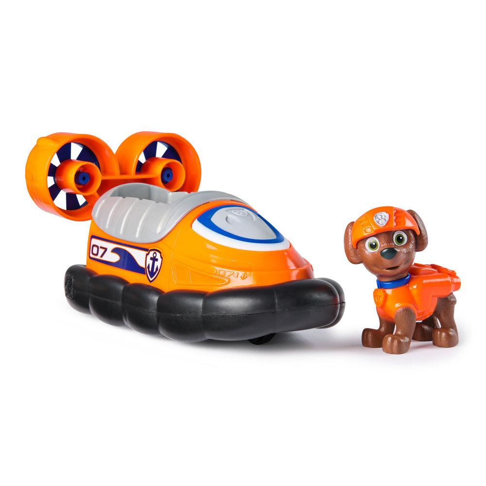Zuma standing next to the PAW Patrol Basic Rescue Vehicle with Zuma playset