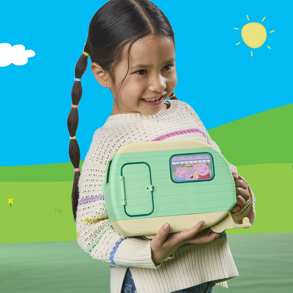 Girl holding the Peppa Pig Three Little Piggies Caravan playset