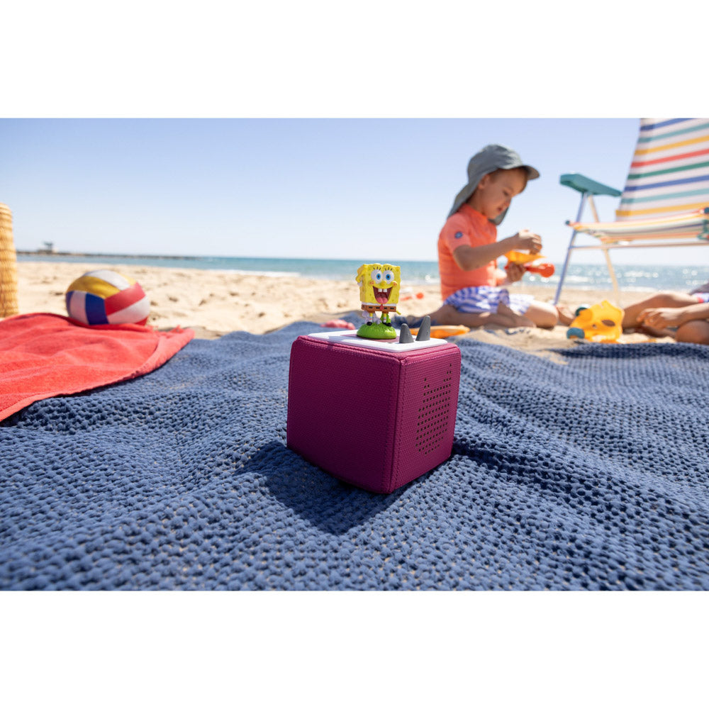 Child at the beach with their Tonies Audio Character Spongebob Squarepants figure