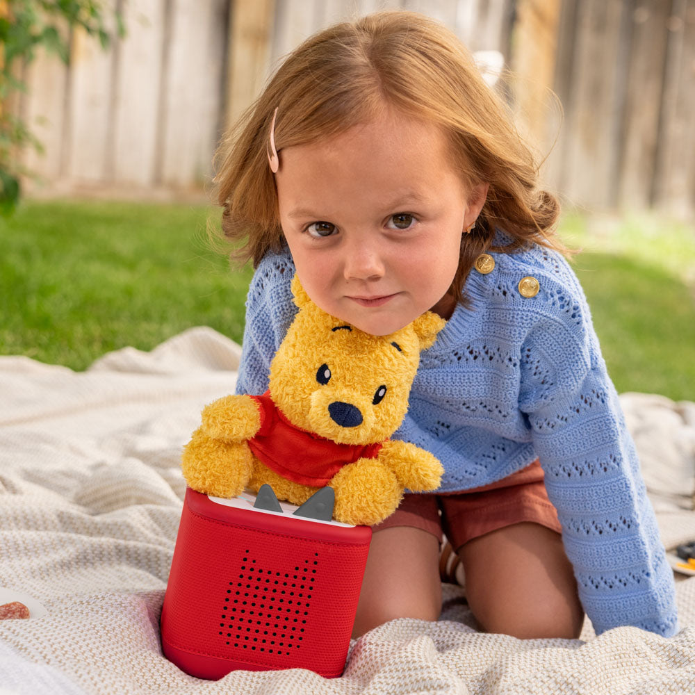 Child playing with the Tonies Cuddle Tonie Winnie The Pooh plush figure