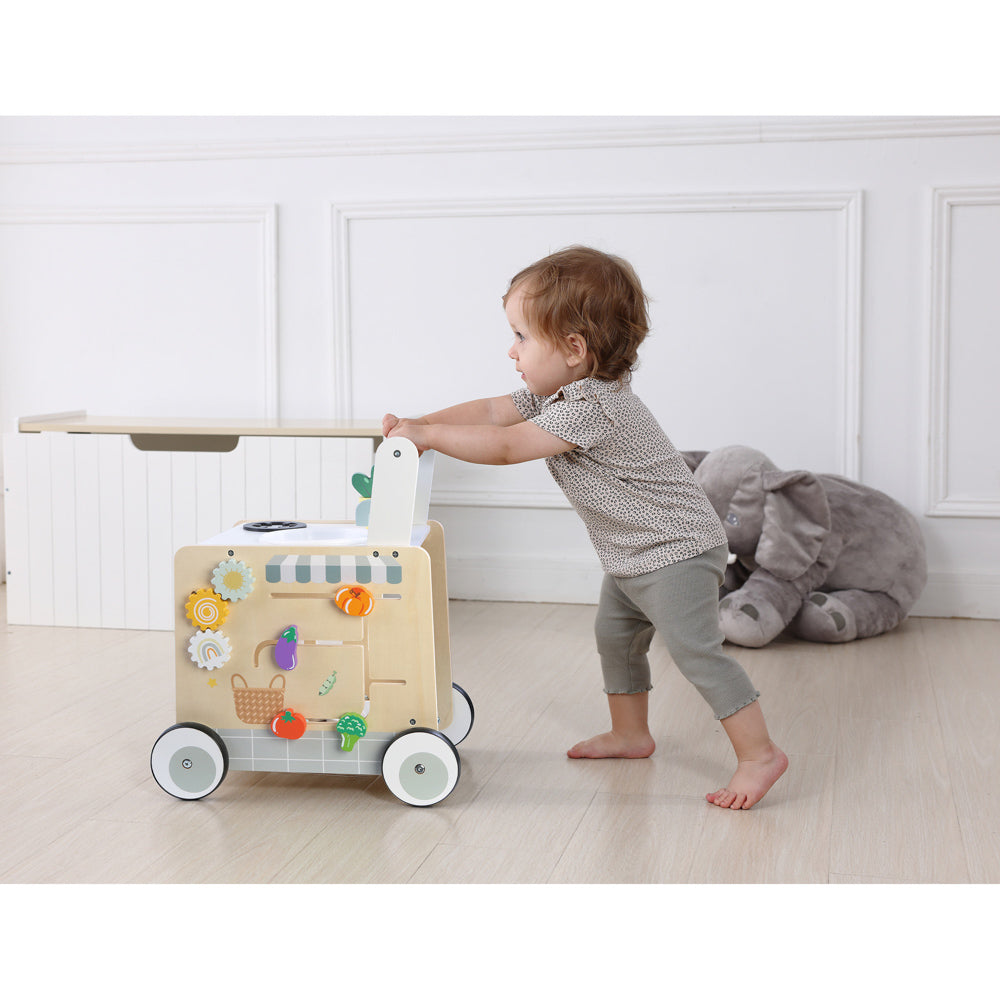 Baby using the Wooden Cooking Activity Walker with oven, sink, and stove.