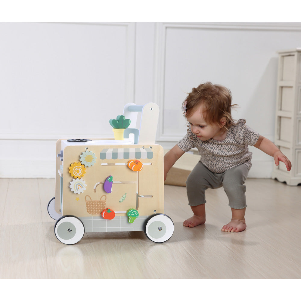 Baby using the Wooden Cooking Activity Walker with oven, sink, and stove.