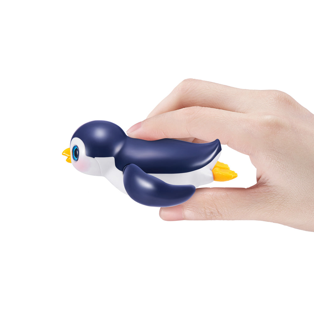 Hand holding the navy ZURU Pets Alive Swimming Penguin Series 1 Bath Toy - Assorted Styles
